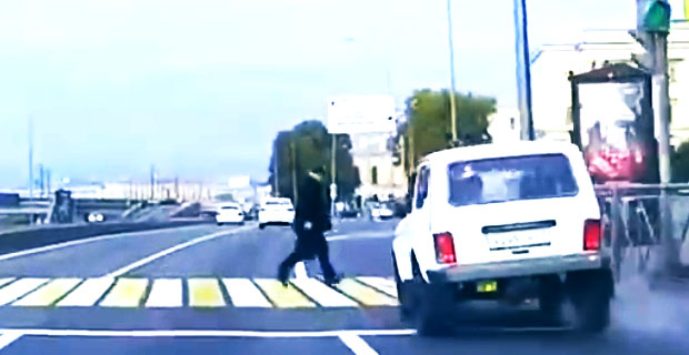 Facet na przejściu dla pieszych i facet w białej Ładzie